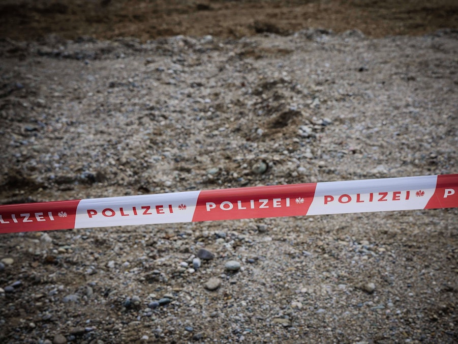 Polizei-Absperrband auf Kiesboden