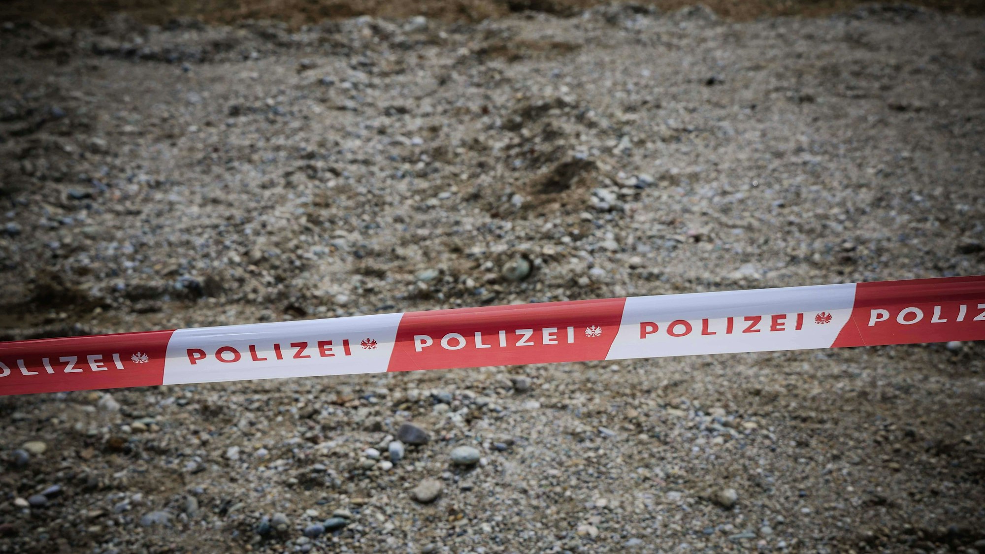 Polizei-Absperrband auf Kiesboden