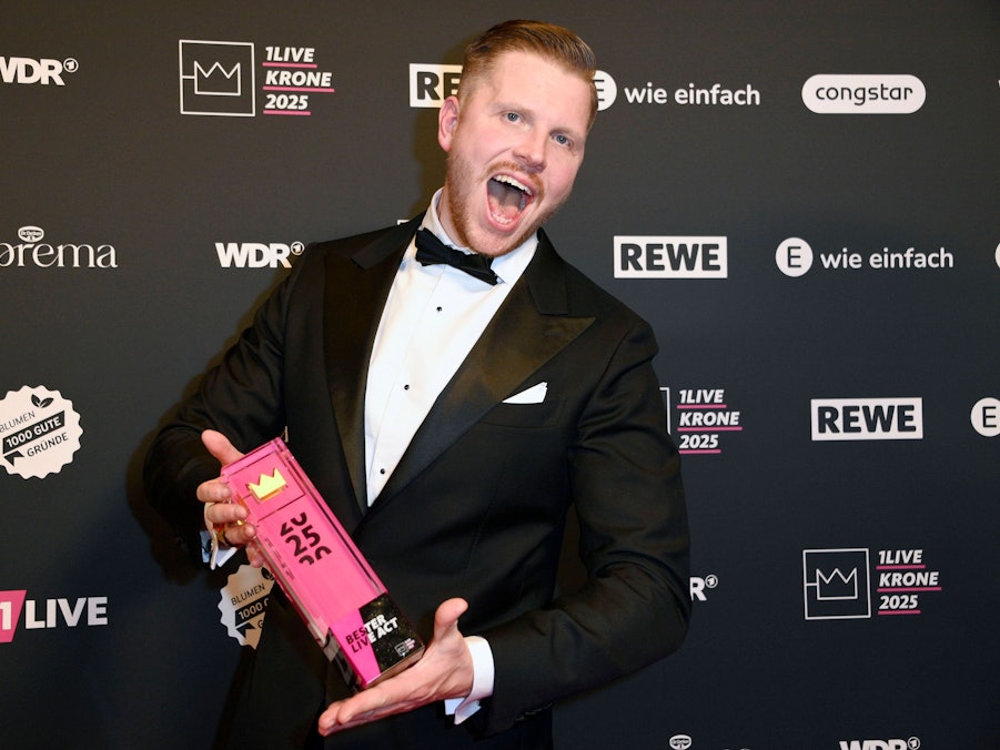 Rapper Finch hält eine Trophäe