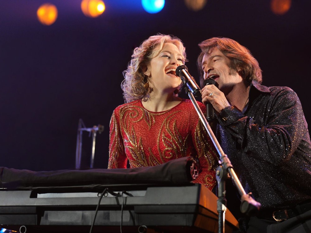 Claire (Kate Hudson) und Mike Sardina (Hugh Jackman) sind wie Blitz und Donner, sie gehören einfach zusammen: Als Neil-Diamond-Tribute-Band nennen sie sich Thunder & Lightning. (Bild: 2025 Focus Features, LLC./Sarah Shatz/Plaion Pictures/Universal)