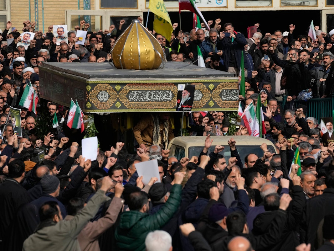 Menschen folgen einem Lastwagen, der die mit Flaggen bedeckten Särge von General Ali Mohammad Naeini, einem Sprecher der paramilitärischen iranischen Revolutionsgarde, und einem seiner Kameraden, Amir Hossein Bidi, während ihres Trauerzuges in Teheran transportiert.