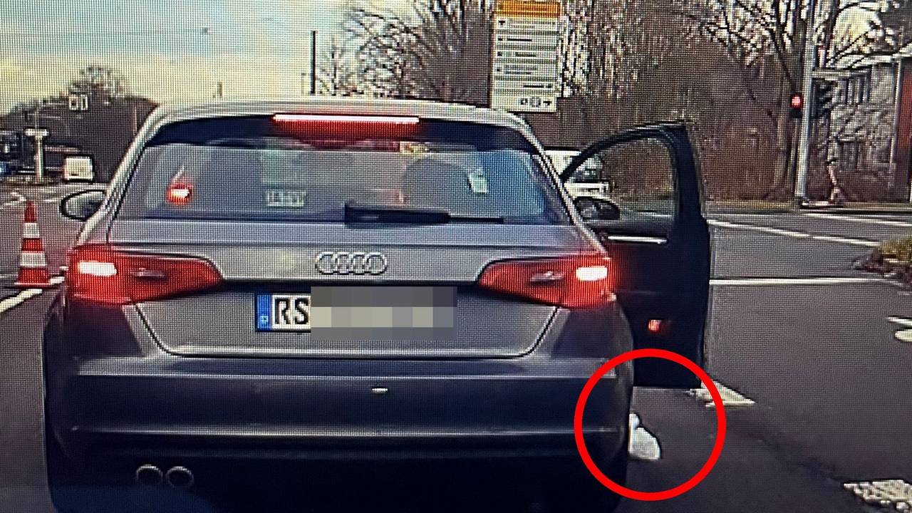 Hier wirft der Beifahrer Müll aus dem Auto an einer Kölner Ampel.