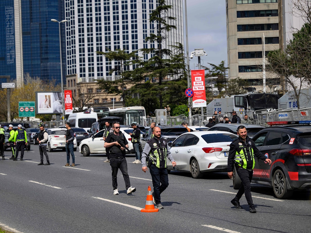 Polizisten sind auf einer Straße im Einsatz. Einige sind schwer bewaffnet.
