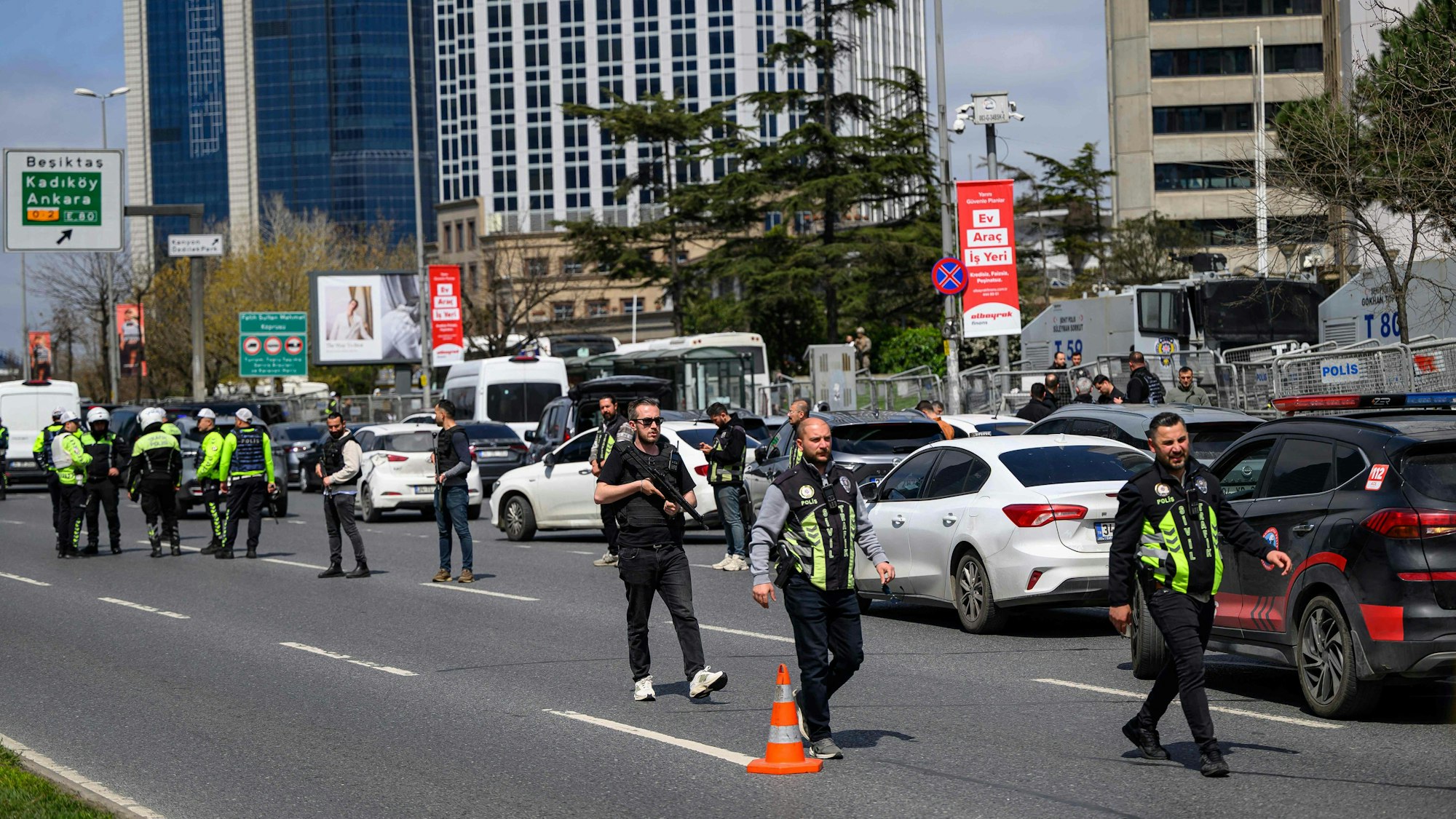 Polizisten sind auf einer Straße im Einsatz. Einige sind schwer bewaffnet.