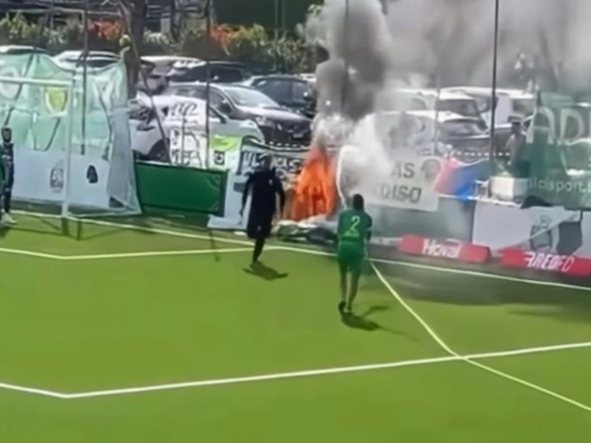Ein Spieler löscht mit einem Schlauch ein Feuer hinter dem Tor.