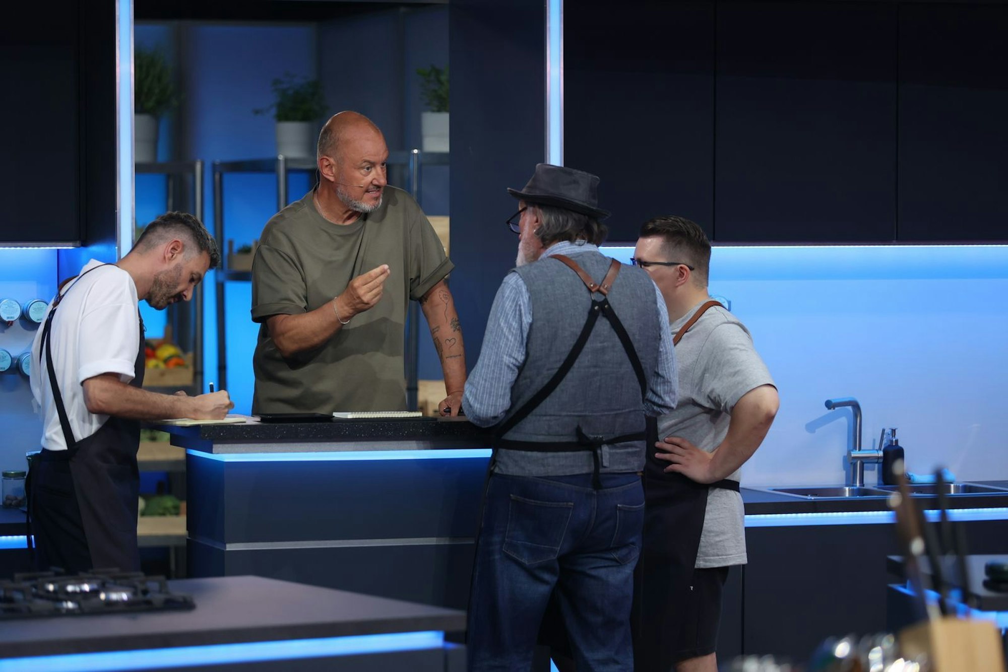 Frank Rosin gibt Jochen Schropp (links), Andreas Hoppe (Zweiter von rechts) und Paul Cooks (rechts) sofort Anweisungen. (Bild: Joyn / Benedikt Müller)