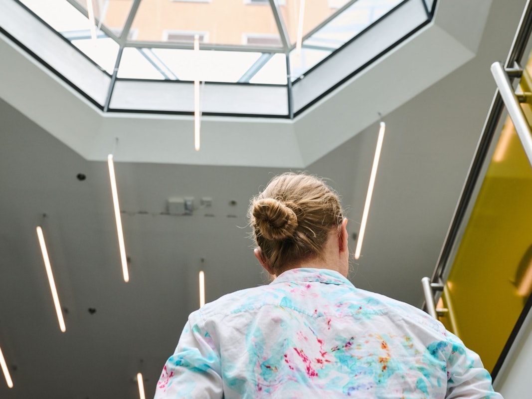 Eine Frau geht in einem Bürohaus eine Treppe hoch