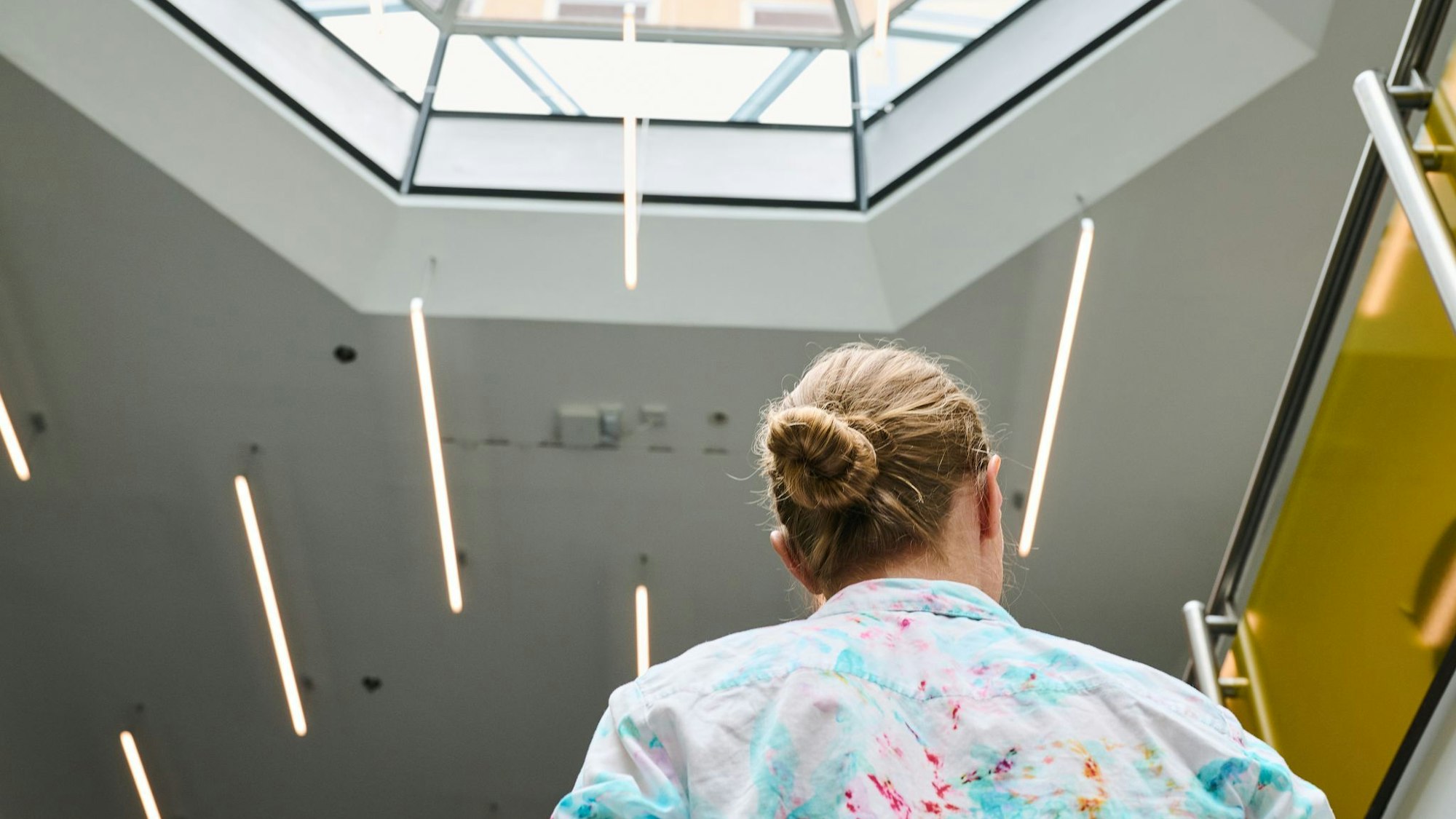 Eine Frau geht in einem Bürohaus eine Treppe hoch