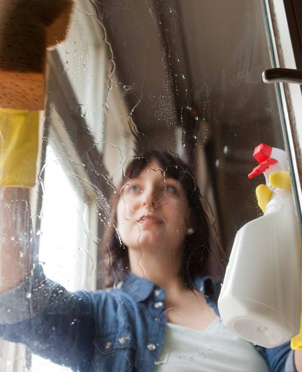 Eine Frau putzt Fenster