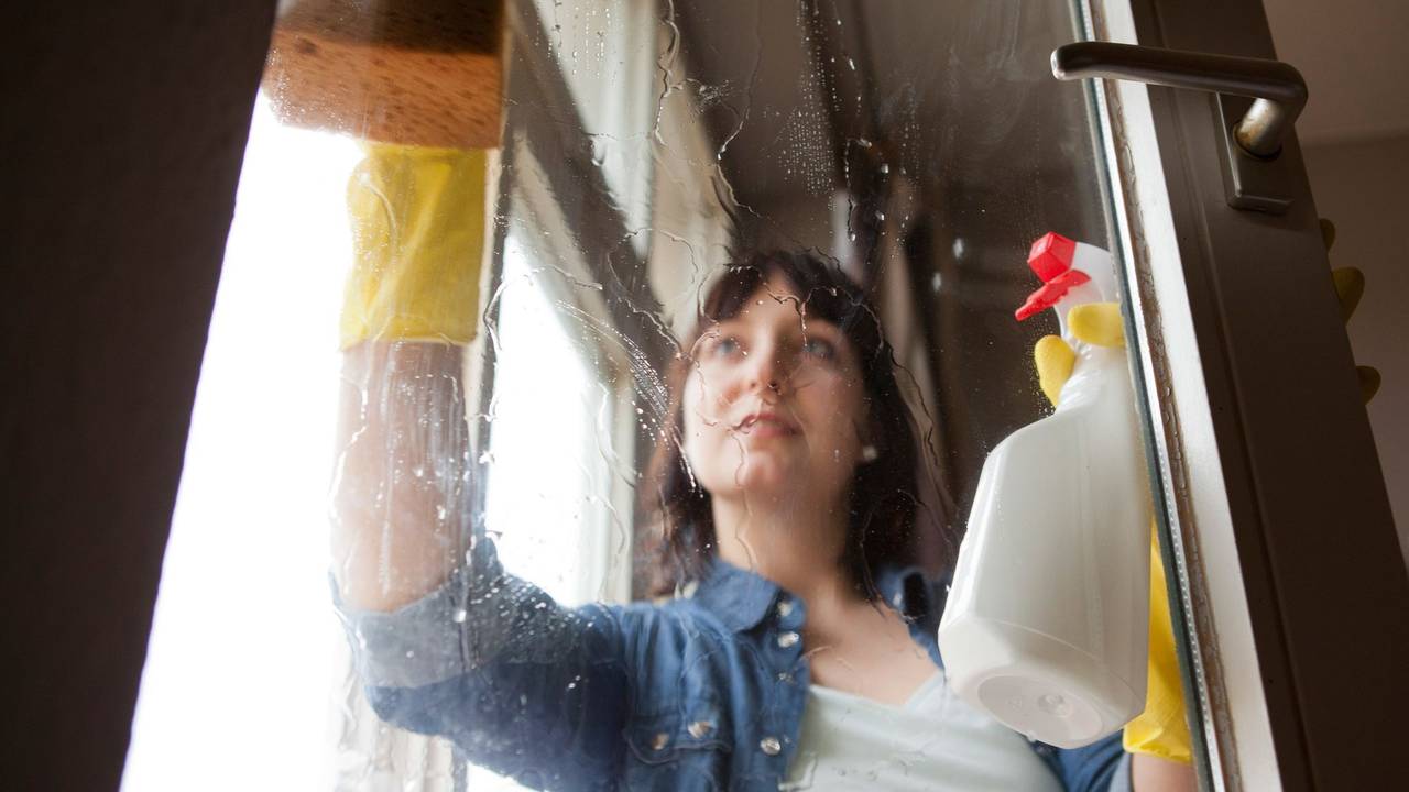 Eine Frau putzt Fenster