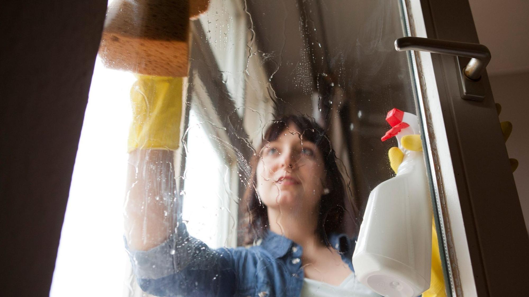 Eine Frau putzt Fenster