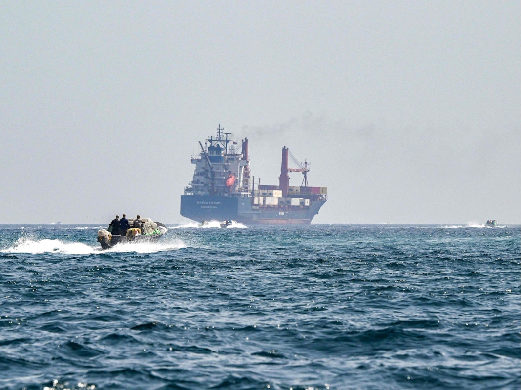 Ein Boot nähert sich dem unter der Flagge von St. Kitts und Nevis fahrenden Containerschiff „Marsa Victory“ in den Gewässern der Straße von Hormus vor der Küste von Khasab (Archivbild).