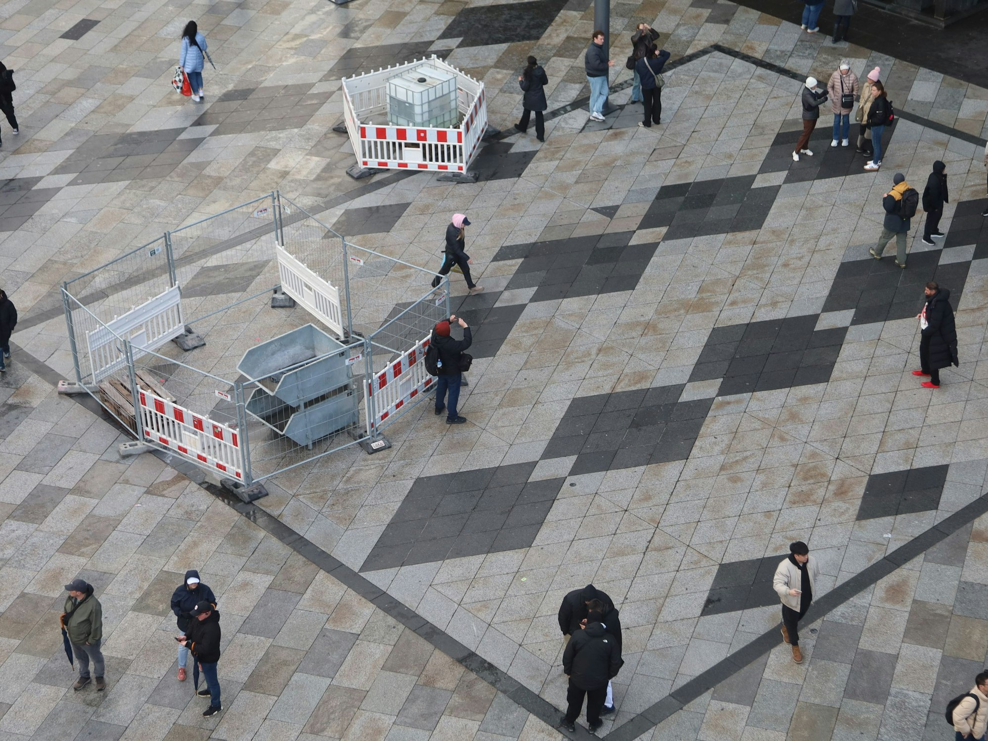 Auf der Domplatte sind einzelne Stellen abgesperrt worden, Menschen laufen drumherum.