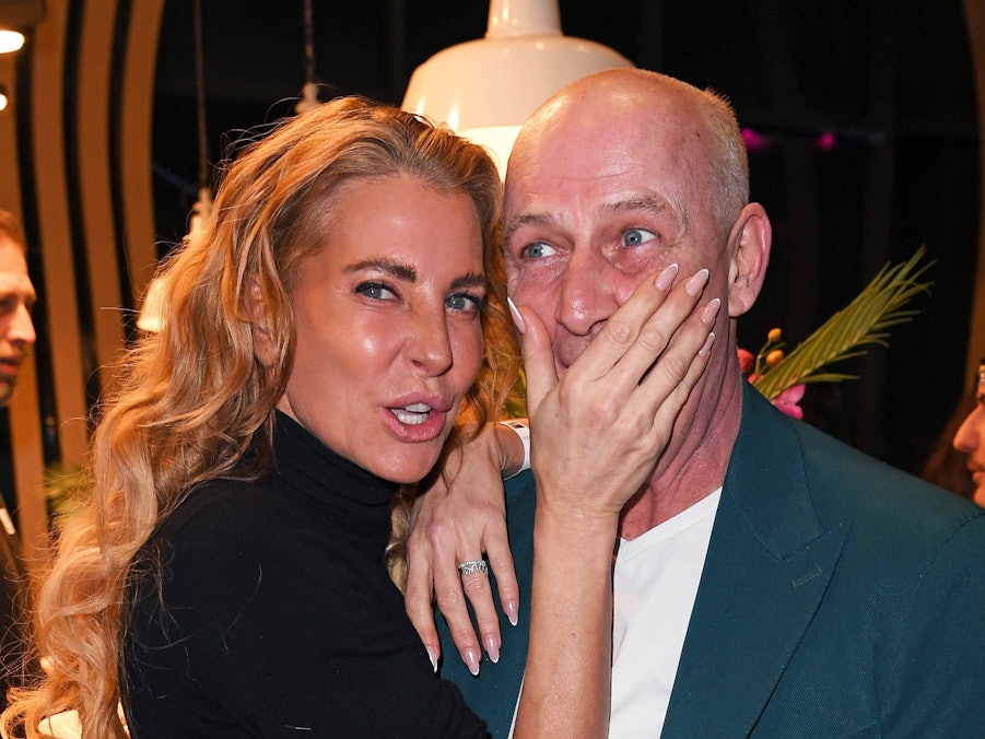 Giulia Siegel hält Mario Basler die Hand vor den Mund.