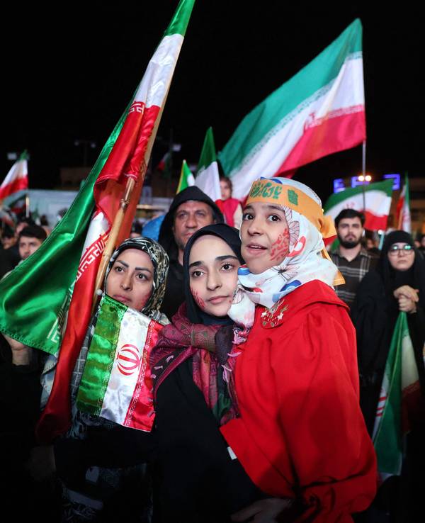 Menschen versammeln sich mit Iran-Fahnen.