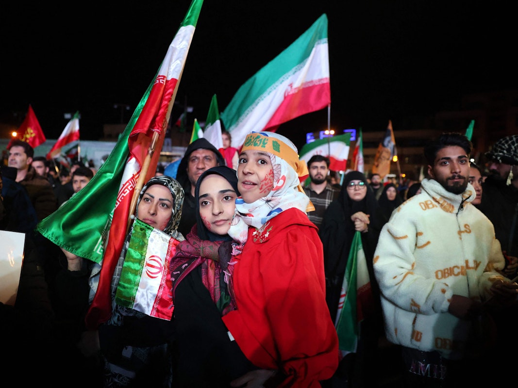 Menschen versammeln sich mit Iran-Fahnen.