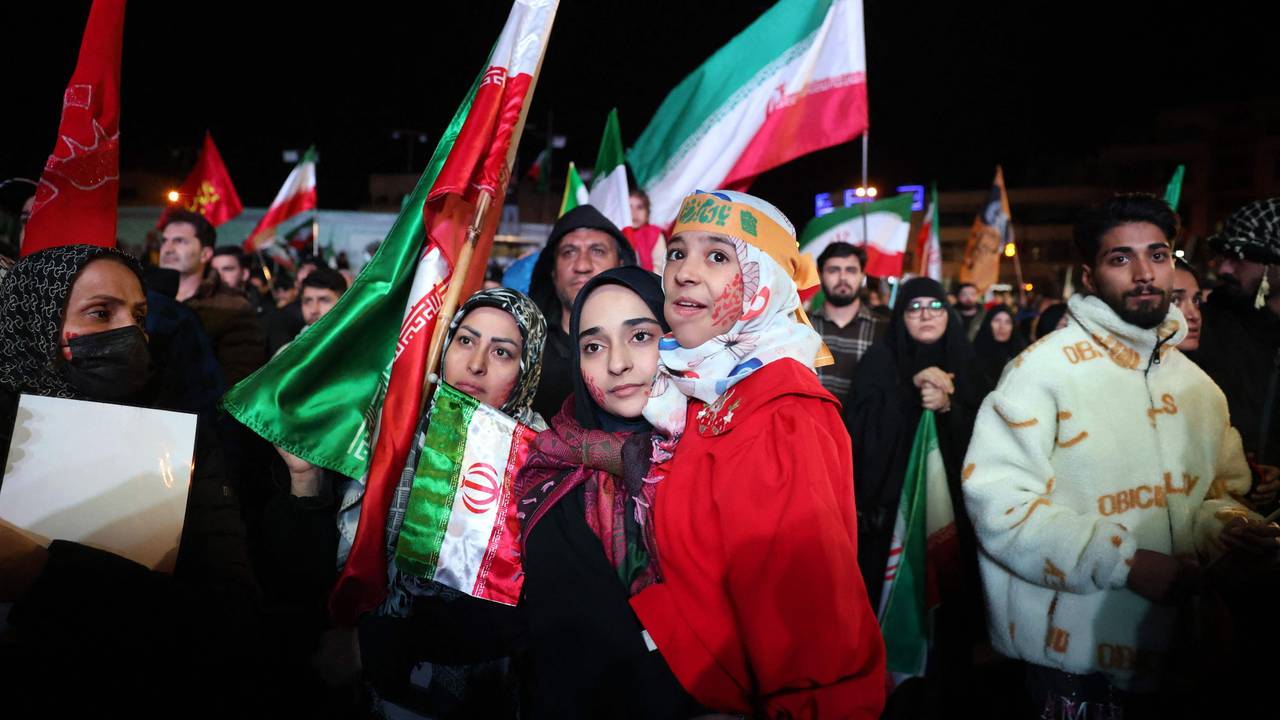 Menschen versammeln sich mit Iran-Fahnen.