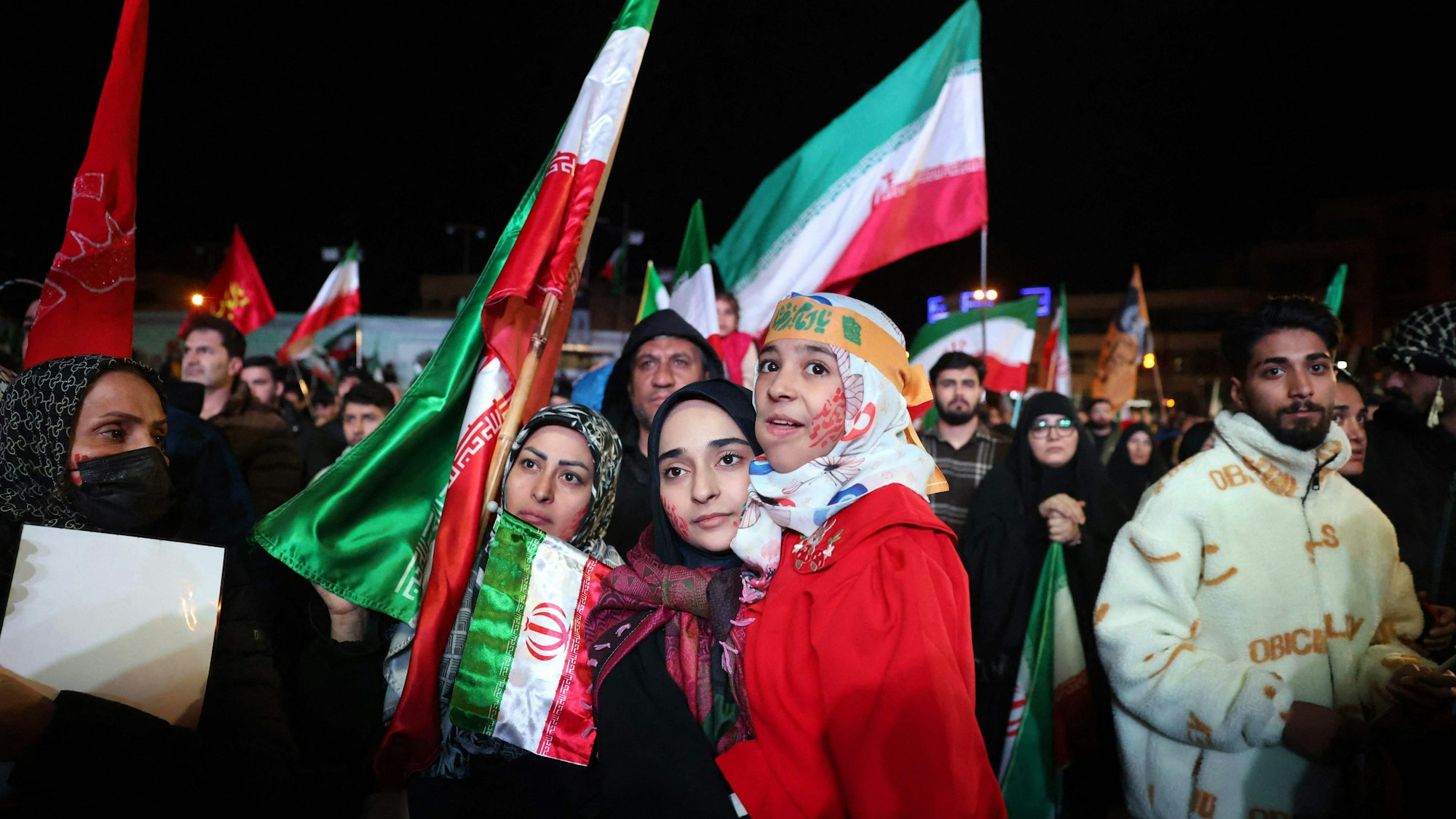 Menschen versammeln sich mit Iran-Fahnen.