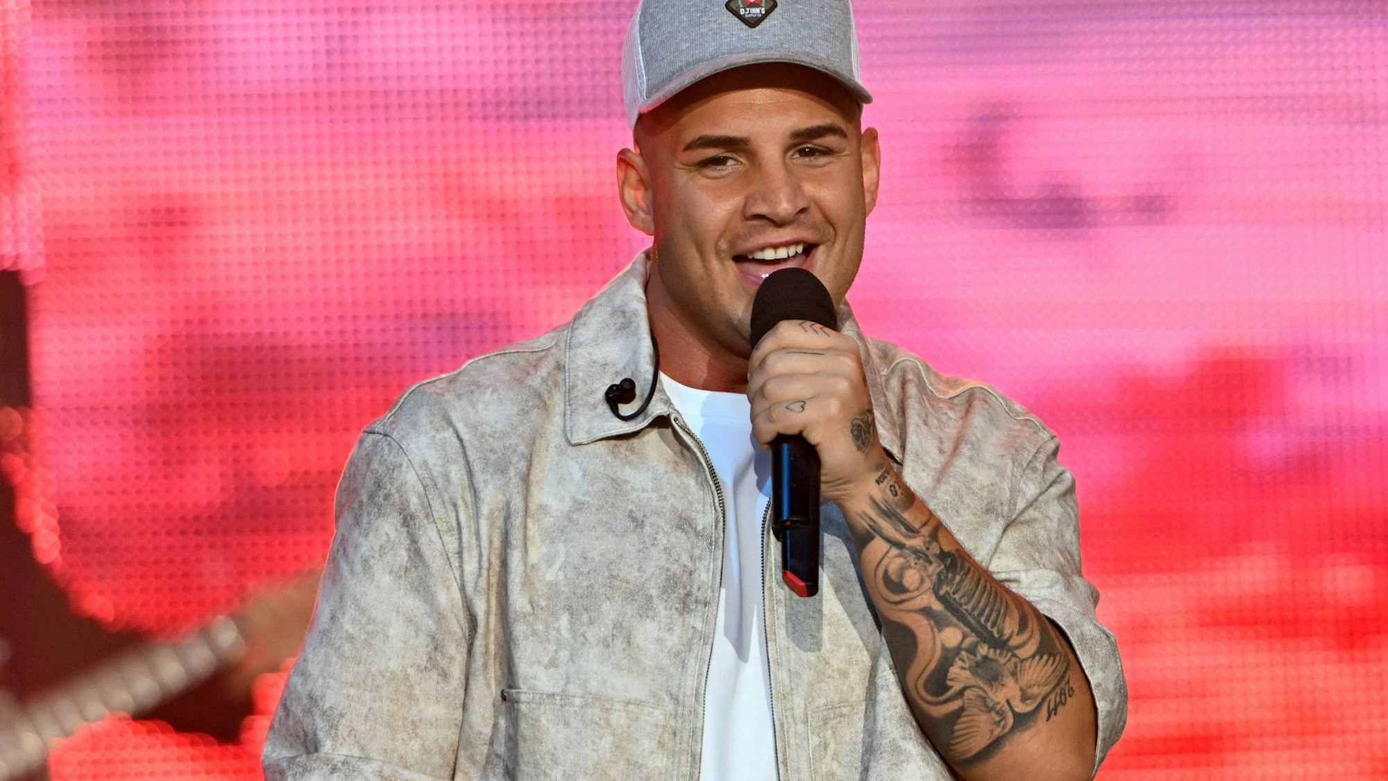 Pietro Lombardi mit Kappe, Jacke und Mikrofon