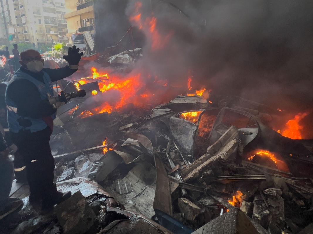 Ein Rettungsarbeiter löscht am 8. April 2026 brennende Autos am Ort eines israelischen Luftangriffs im Zentrum von Beirut.