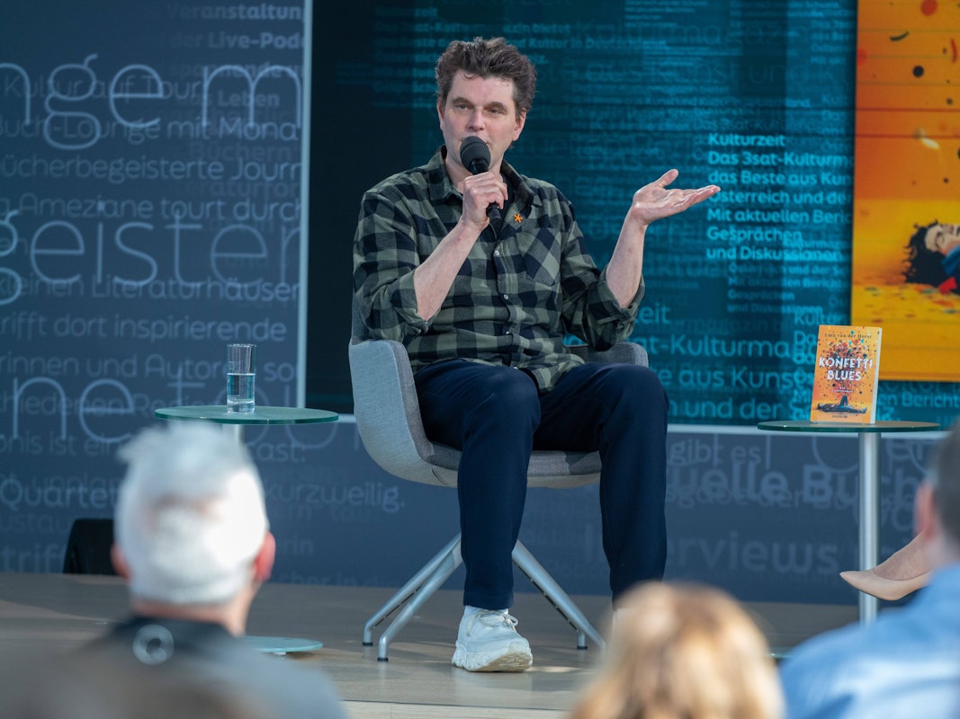Lutz van der Horst mit seinem Buch „Konfetti-Blues“ auf der Bühne von ARD, ZDF und 3sat in der Glashalle der Leipziger Buchmesse 2026.