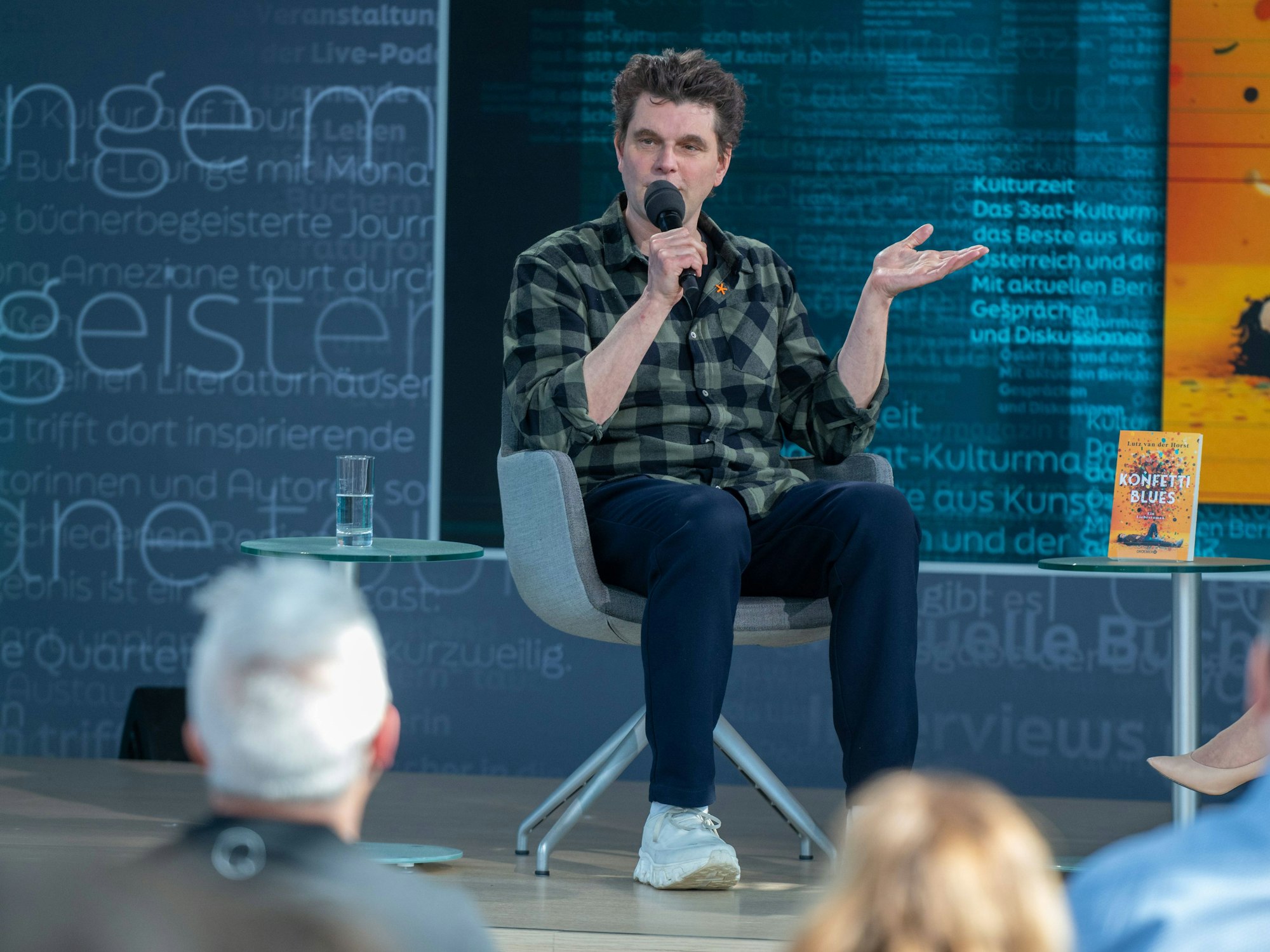 Lutz van der Horst mit seinem Buch „Konfetti-Blues“ auf der Bühne von ARD, ZDF und 3sat in der Glashalle der Leipziger Buchmesse 2026.