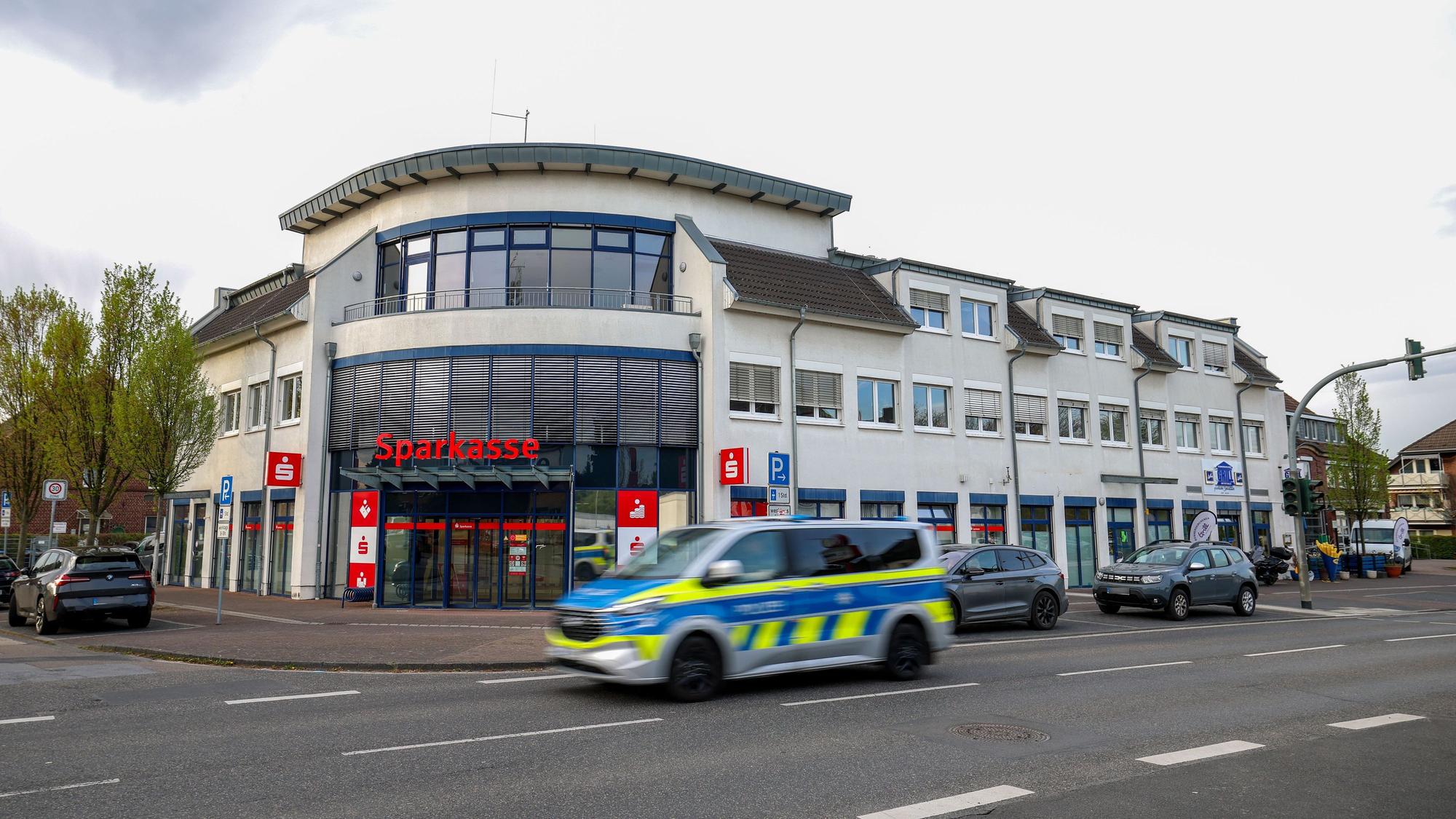 Ein Polizeiauto fährt an einer Sparkassenfiliale vorbei. Ein vermutlich bewaffneter Mann hat mit dem Betreten einer Sparkassenfiliale in Rommerskirchen bei Neuss einen Großeinsatz der Polizei ausgelöst. Nach etwa zwei Stunden habe der Mann sich widerstandslos festnehmen lassen, sagte eine Polizeisprecherin.