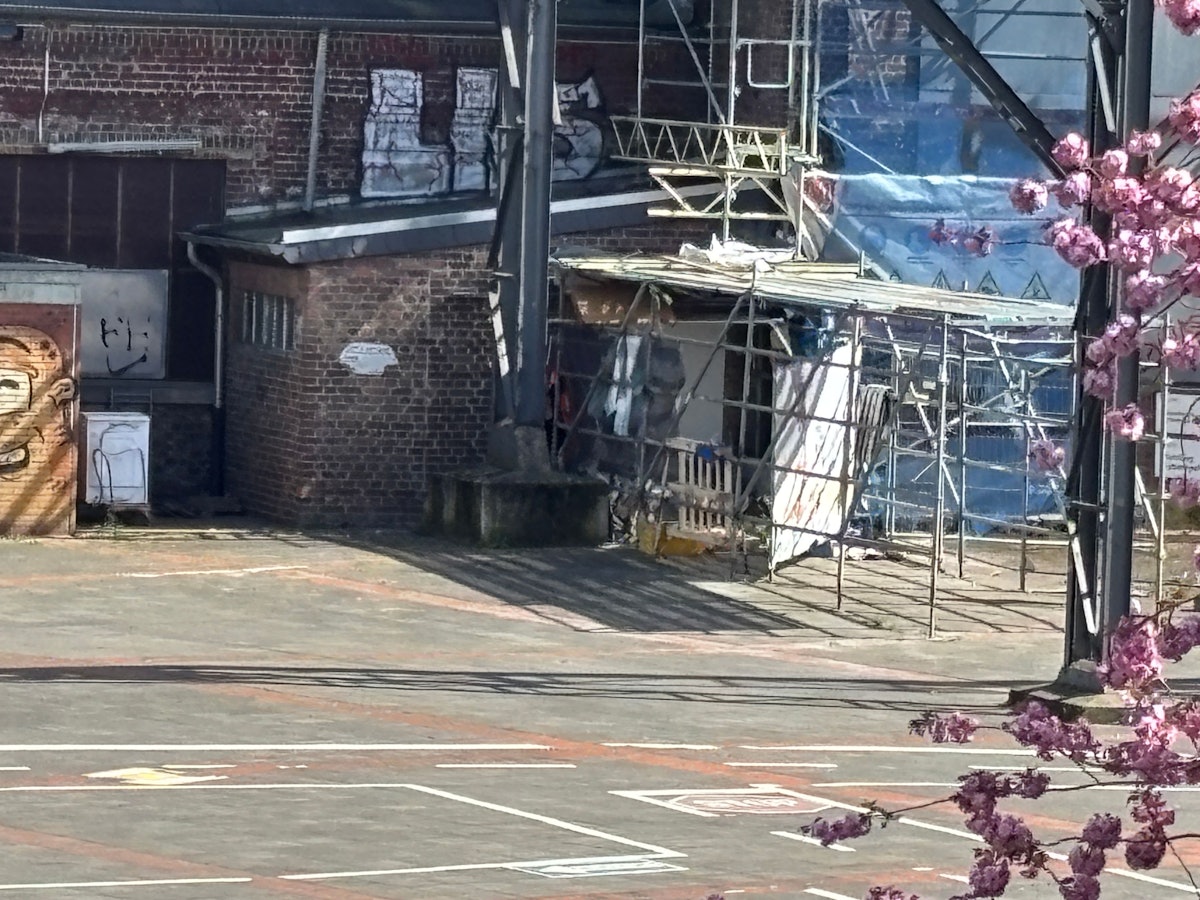 Unterhalb eines Baugerüsts befindet sich ein Schlaflager.