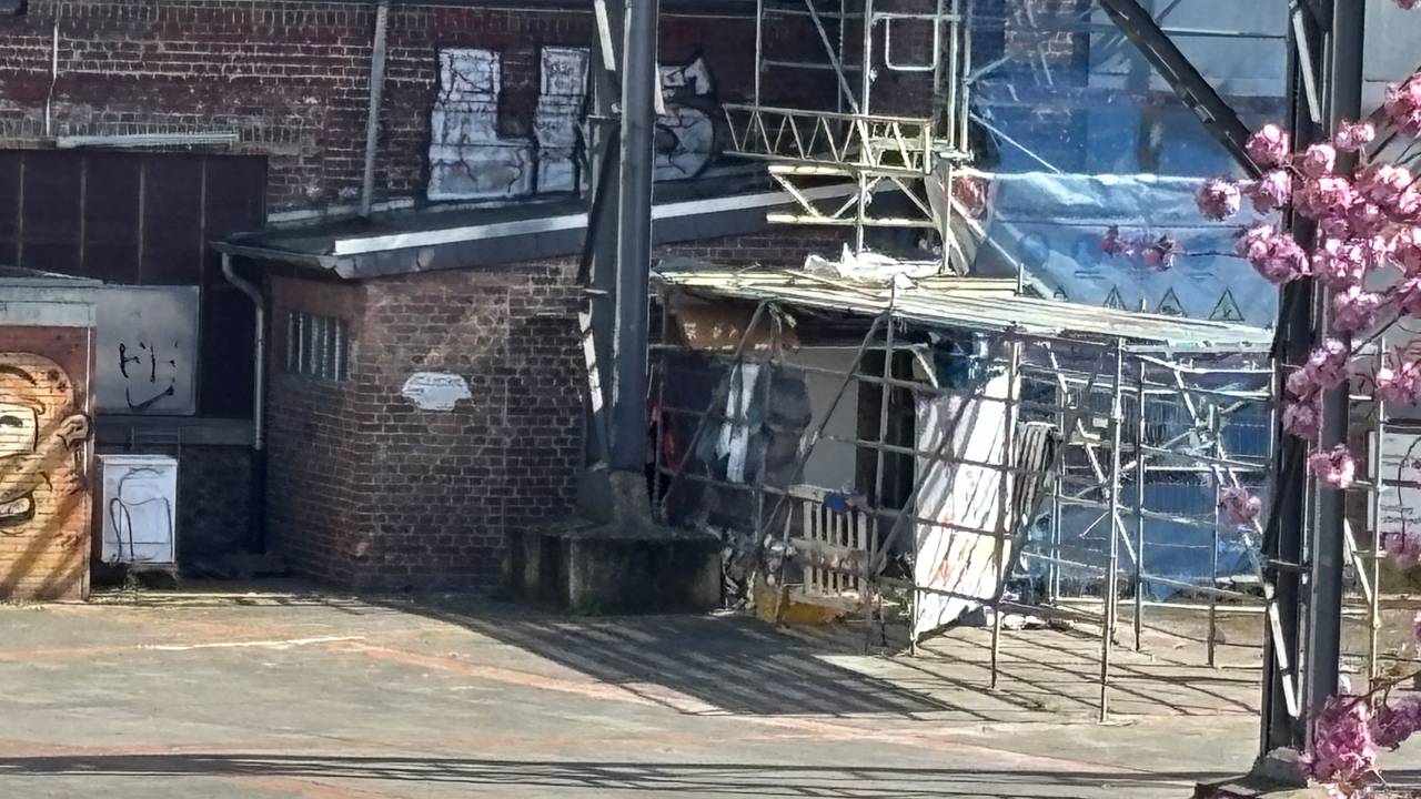 Unterhalb eines Baugerüsts befindet sich ein Schlaflager.