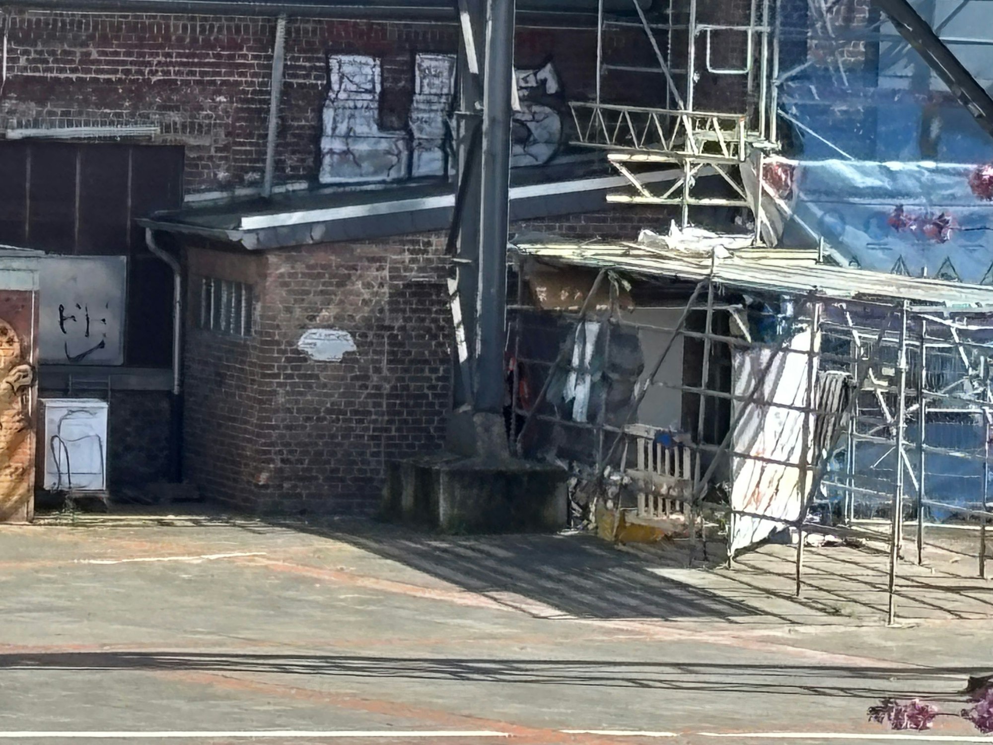 Unterhalb eines Baugerüsts befindet sich ein Schlaflager.