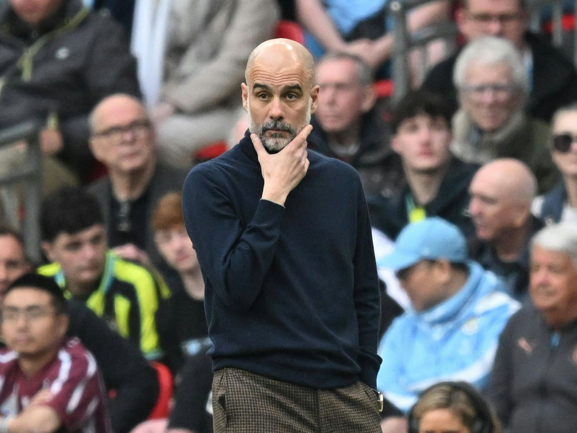 Trainer Pep Guardiola steht nachdenklich an der Seitenlinie.
