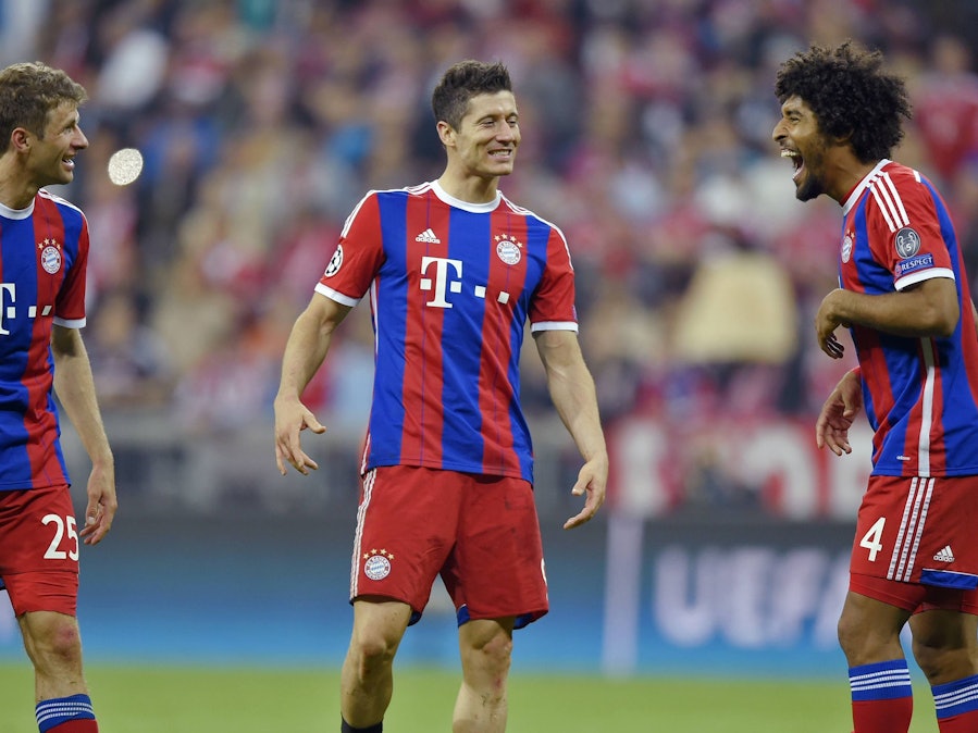 Thomas Müller, Robert Lewandowski (M.) und Dante (r.) unterhalten sich auf dem Feld.