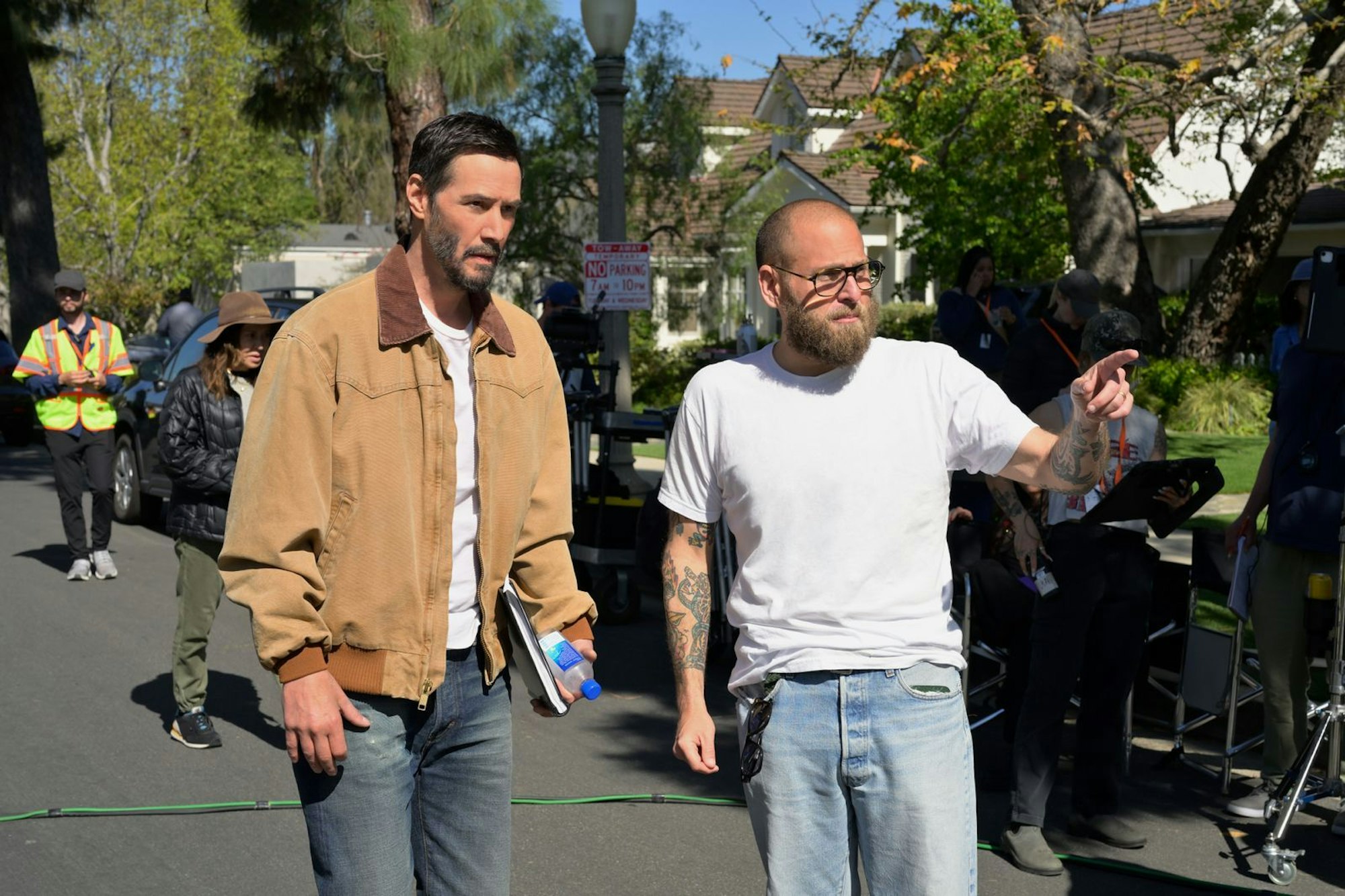 Keanu Reeves (links) und Jonah Hill laufen über das Set von „Outcome“. Hill ist Regisseur des Films und hat am Drehbuch mitgeschrieben. (Bild: Apple TV)