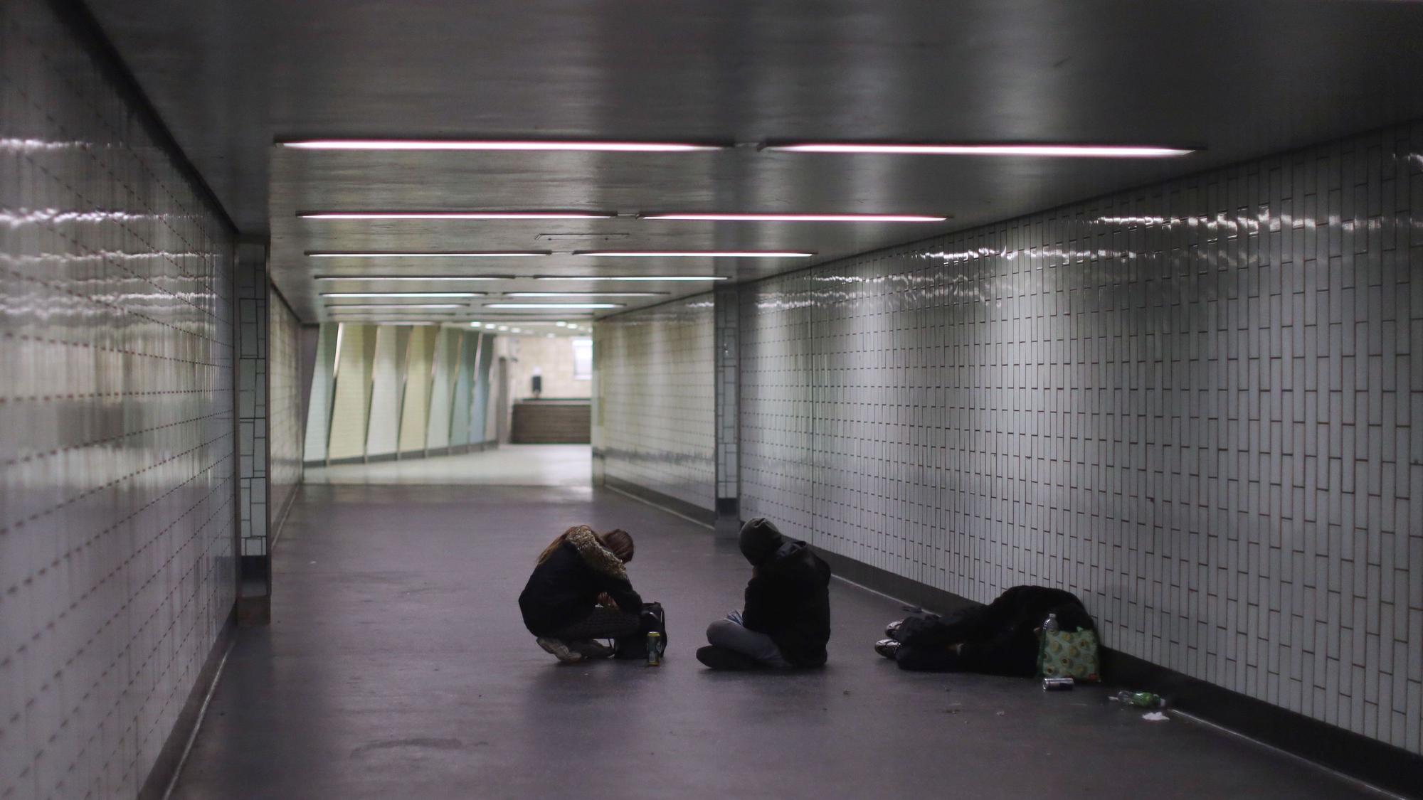 An der Haltestelle Appellhofplatz liegen beziehungsweise sitzen Menschen auf dem Boden.