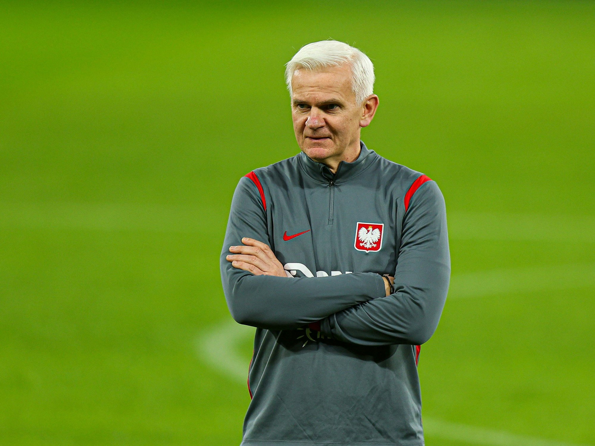 Jacek Magiera steht mit verschränkten Armen auf dem Trainingsplatz.