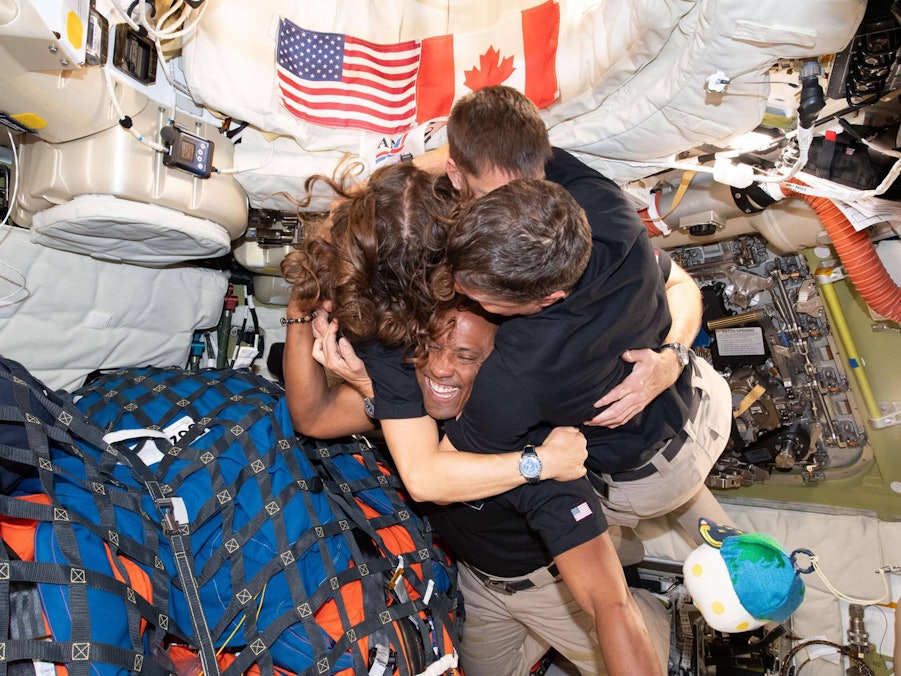 Victor Glover, Christina Koch, Jeremy Hansen und Reid Wiseman umarmen sich