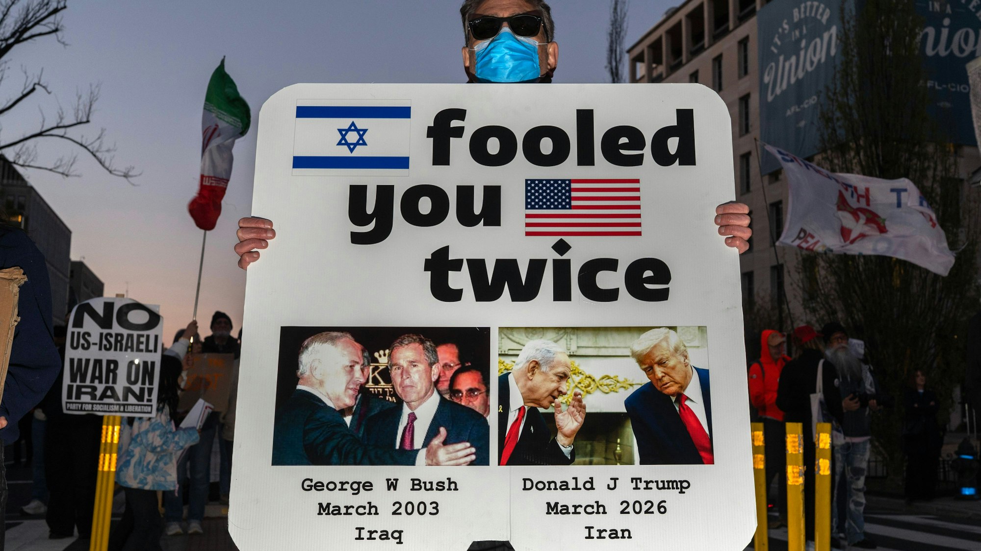 Demonstrant mit Schild, George W Bush und Donald Trump
