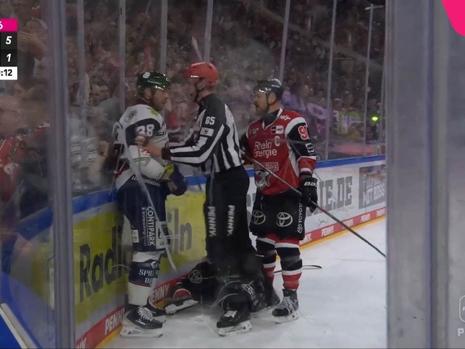 Yannick Veilleux wird nach seinem Crosscheck von den Schiris und Haie-Kapitän Mo Müller zur Rede gestellt.