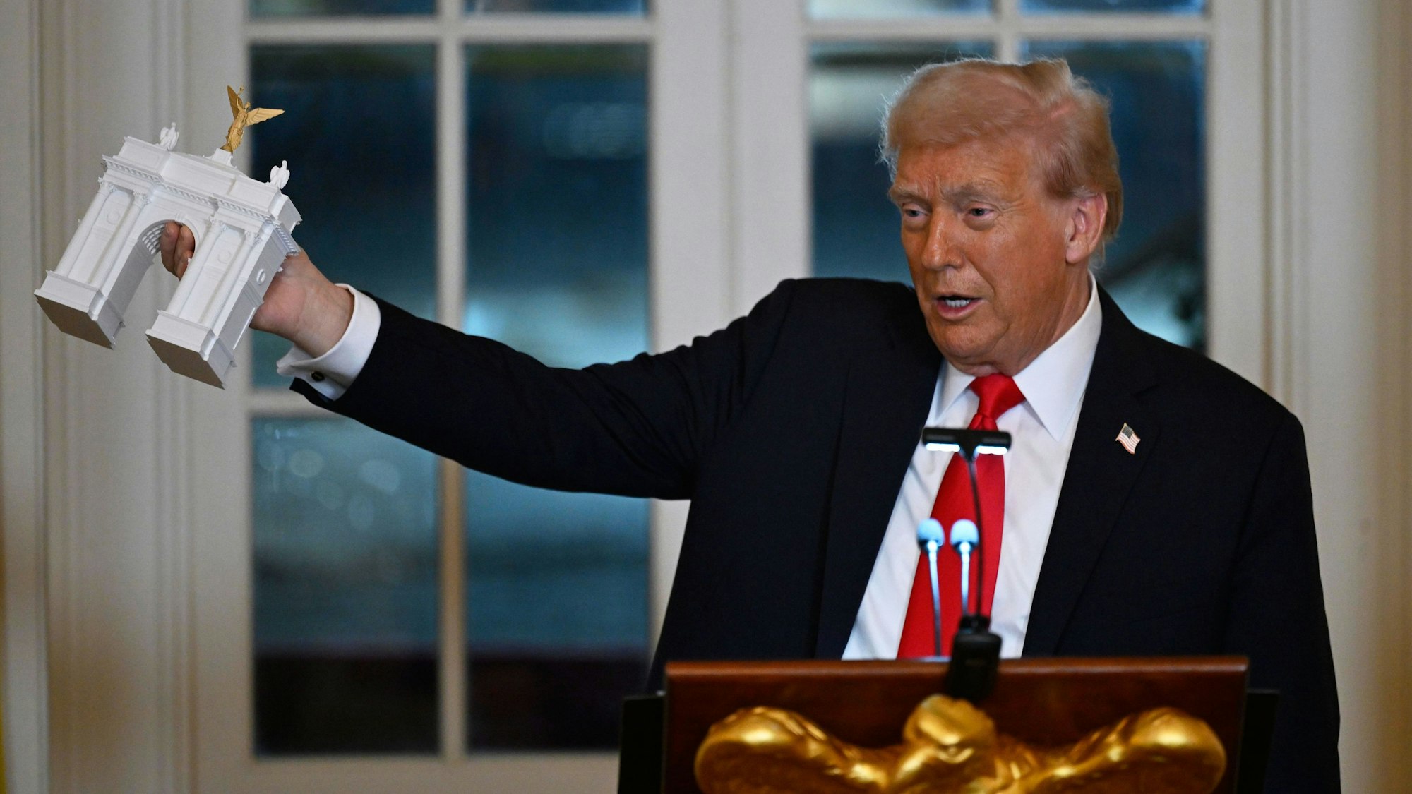 US-Präsident Donald Trump zeigt bei einem Abendessen für Spender, die zum Bau des neuen Ballsaals im Weißen Haus beigetragen haben, das Modell eines Triumphbogens. (Archivbild)