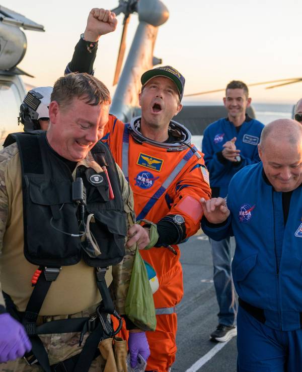 Astronaut Reid Wiseman, Kommandant von Artemis II, wird vom Flugdeck begleitet.