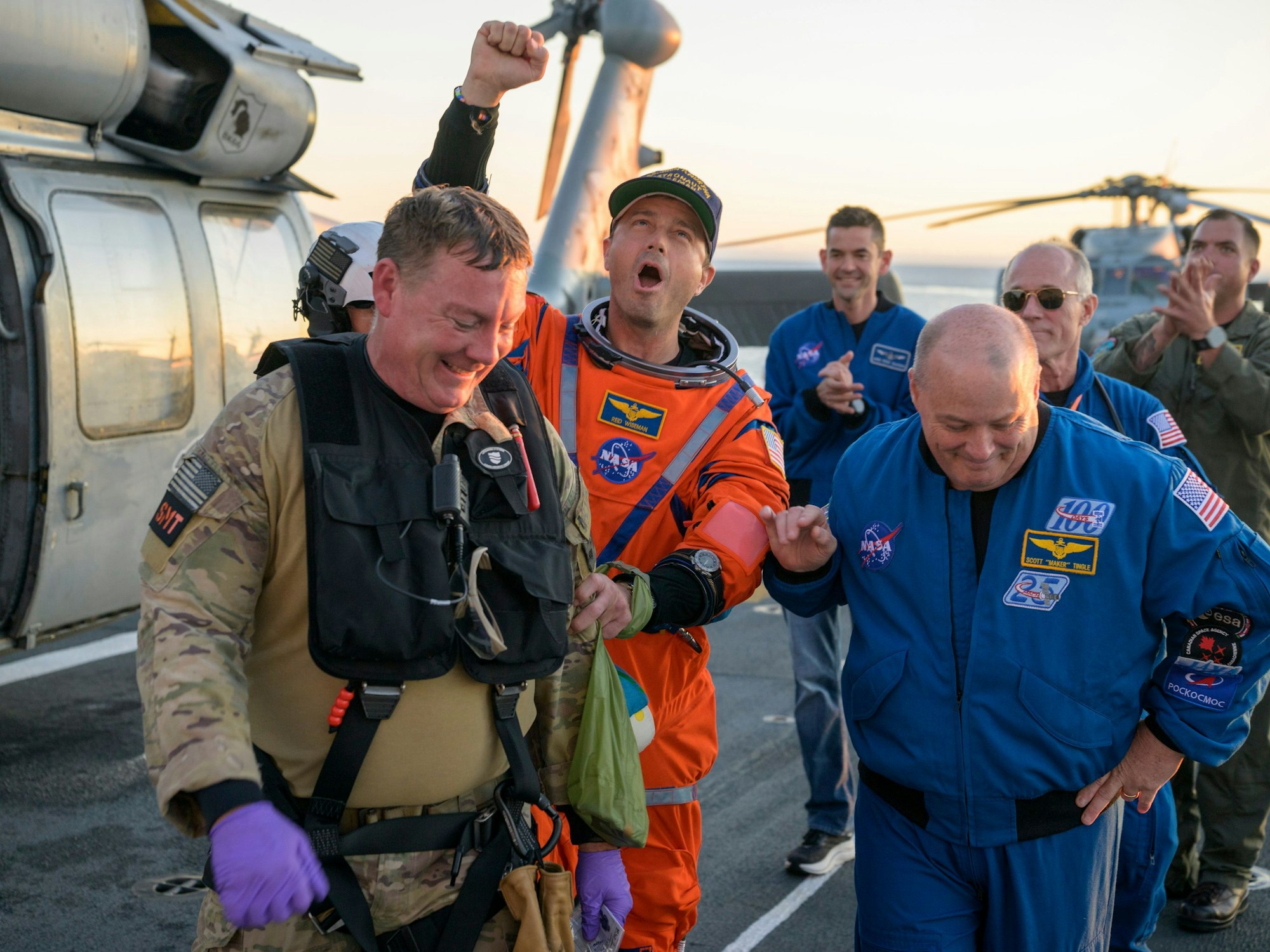 Astronaut Reid Wiseman, Kommandant von Artemis II, wird vom Flugdeck begleitet.