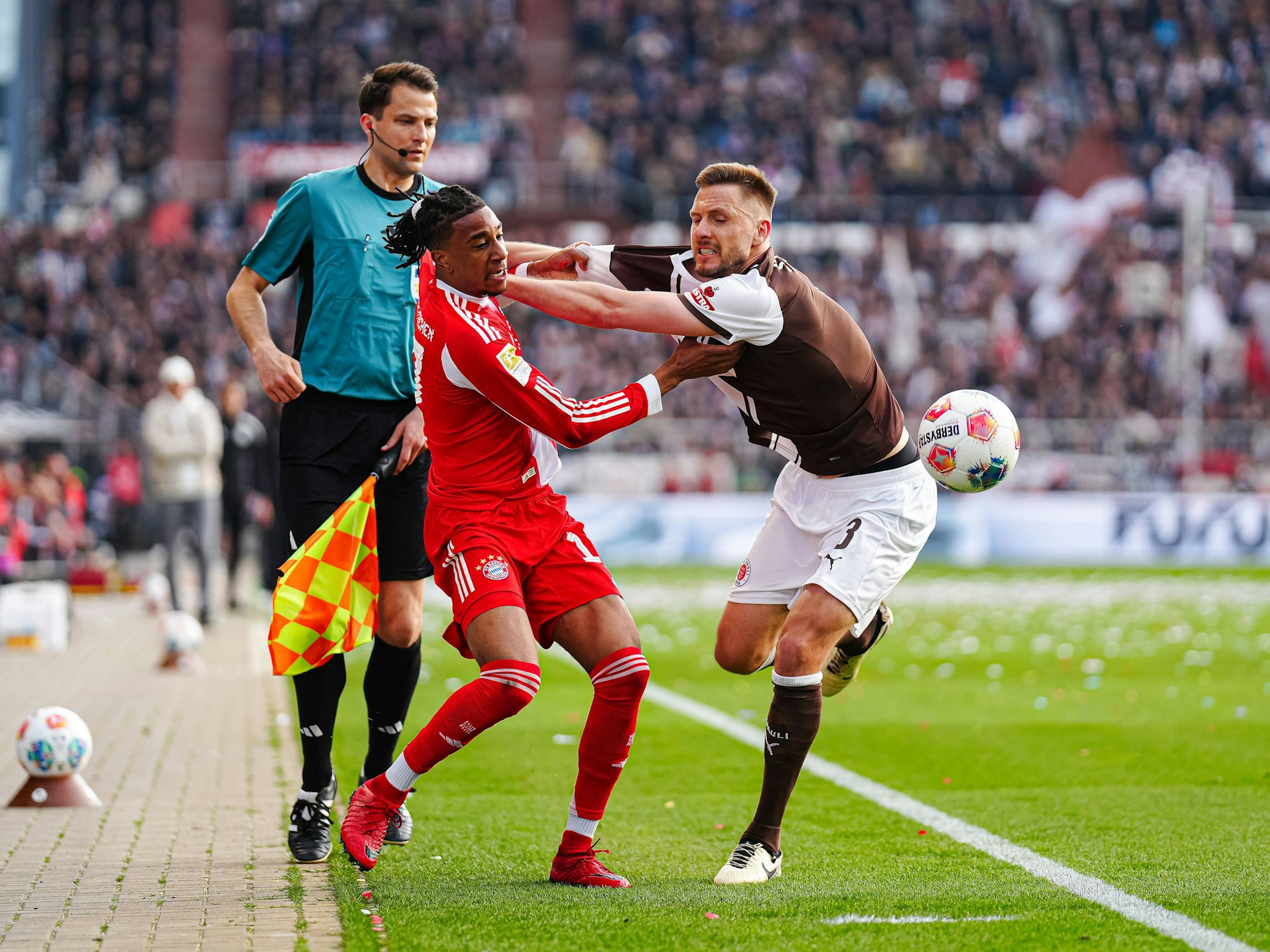 Michael Olise und Karol Mets mit einem Zweikampf an der Seitenlinie.