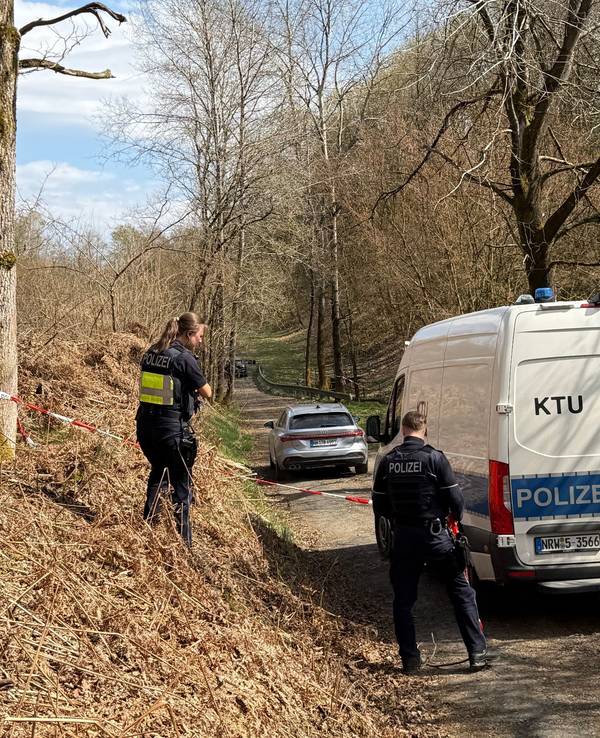Kräfte der Polizei sind in einem mit Flatterband abgesperrten Bereich eines Waldes im Einsatz. Bei einer Müllsammelaktion wurde unweit der A4 ein menschlicher Kopf gefunden.