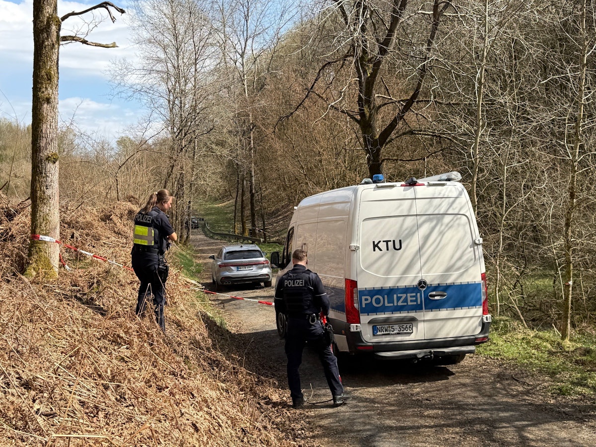 Kräfte der Polizei sind in einem mit Flatterband abgesperrten Bereich eines Waldes im Einsatz. Bei einer Müllsammelaktion wurde unweit der A4 ein menschlicher Kopf gefunden.