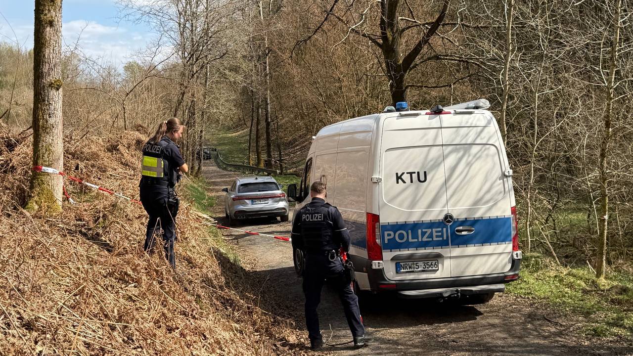 Kräfte der Polizei sind in einem mit Flatterband abgesperrten Bereich eines Waldes im Einsatz. Bei einer Müllsammelaktion wurde unweit der A4 ein menschlicher Kopf gefunden.