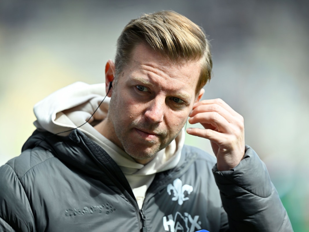 Darmstadt-Trainer Florian Kohfeldt fasst sich ans Ohr.