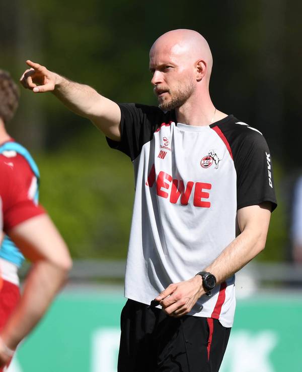 René Wagner gibt auf dem Trainingsplatz Anweisungen und zeigt in eine Richtung.
