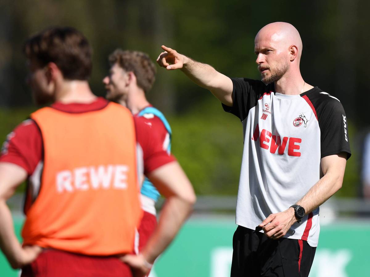 René Wagner gibt auf dem Trainingsplatz Anweisungen und zeigt in eine Richtung.