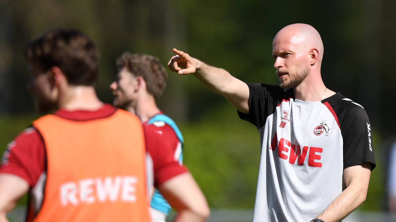 René Wagner gibt auf dem Trainingsplatz Anweisungen und zeigt in eine Richtung.