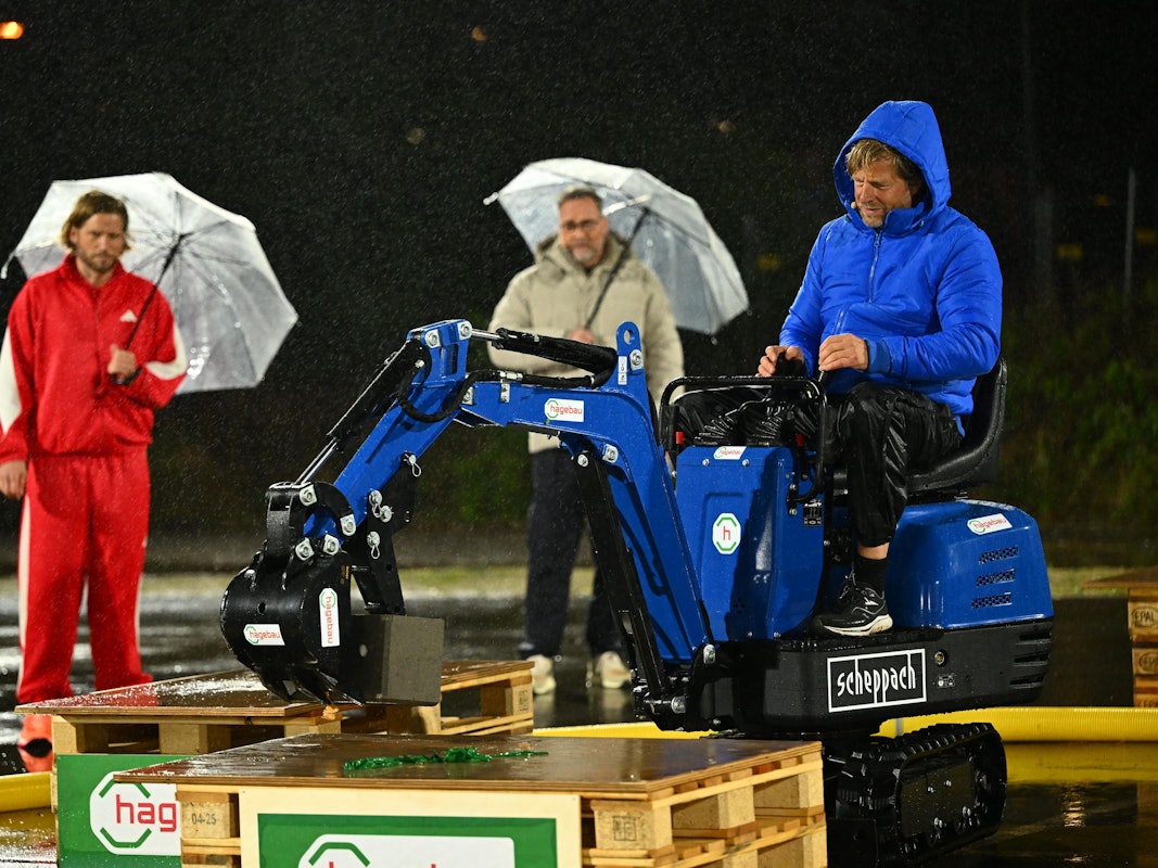 Henning Baum baggert bei Schlag den Star, während Kontrahent Sebastian Ströbel und Moderator Matthias Opdenhövel zuschauen.
